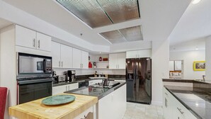 A modern kitchen with white cabinets, a central island, stainless steel appliances, and a skylight. - Family-Friendly townhouse near lake - convenient & walkable location (Incline Village)