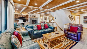 A spacious living area with leather sofas, a fireplace, and a wooden ceiling. - Comfortable Townhome with Pool, Deck, & Lovely Sunsets - Walk to Lake (Kings Beach)