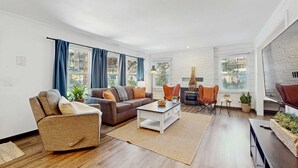Een moderne woonkamer met een bank, fauteuil, salontafel en een open haard.