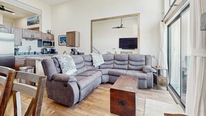 A modern living room with a sectional sofa, a wooden coffee table, and a kitchen in the background. - Luxury Condo in Stateline: Lake & Mountain Views (Stateline)