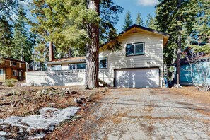 A two-story house with a garage, surrounded by trees and a dry, cracked ground. - Complimentary paddle boards and a relaxing sauna just steps from Lake Tahoe. (Carnelian Bay)