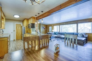 A spacious living area with a wooden dining table, a sofa set, and a kitchen with wooden cabinets and appliances. - Complimentary paddle boards and a relaxing sauna just steps from Lake Tahoe. (Carnelian Bay)