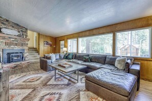 A cozy living room with a fireplace, a large sectional sofa, and a patterned rug. - Complimentary paddle boards and a relaxing sauna just steps from Lake Tahoe. (Carnelian Bay)