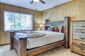 A bedroom with a wooden bed, a nightstand, a dresser, and a window with blinds. - Complimentary paddle boards and a relaxing sauna just steps from Lake Tahoe. (Carnelian Bay)