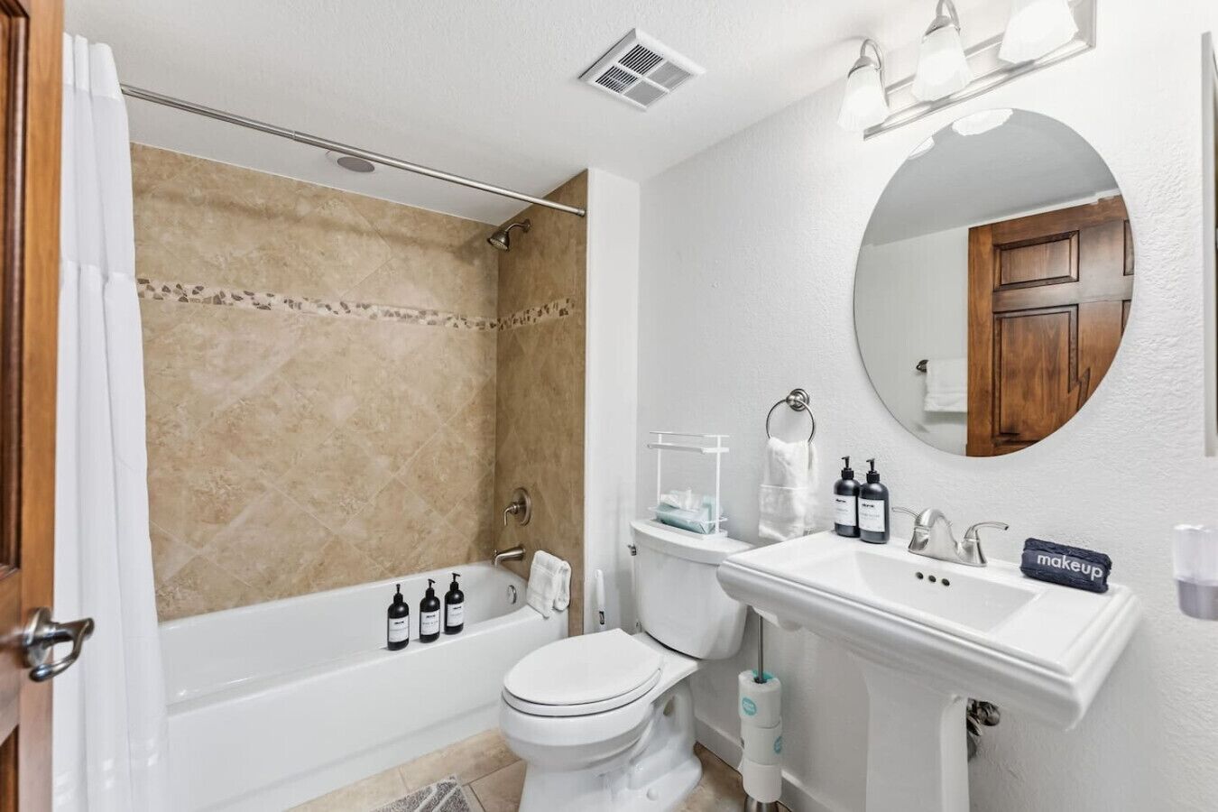 A bathroom with a bathtub, toilet, sink, and a mirror.