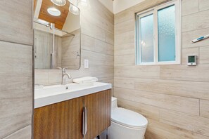A modern bathroom with a wooden vanity, a white sink, a mirror, and a toilet. - Chalet-style Townhome with Fireplace, Deck, Near Ski Resort, Incline Village (Incline Village)