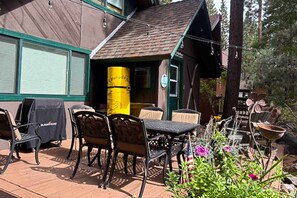 An outdoor patio with a table and chairs, a grill, and a yellow barrel. - Chalet-style Townhome with Fireplace, Deck, Near Ski Resort, Incline Village (Incline Village)