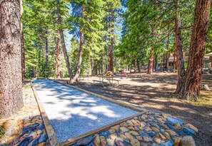 A campground with picnic tables, a fire pit, and a gravel area. - Family-Friendly Condo with Pool, Tennis, Deck & Walk to Beach Access (Kings Beach)
