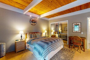 A bedroom with a bed, two bedside tables with lamps, a wooden chair, a rug, and a mirror on the wall. - Family-Friendly Condo with Pool, Tennis, Deck & Walk to Beach Access (Kings Beach)