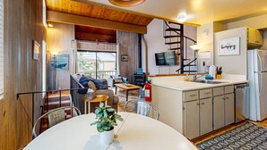 Ein gemütliches Interieur mit Essbereich, Küche und einer Treppe zu einer oberen Ebene.