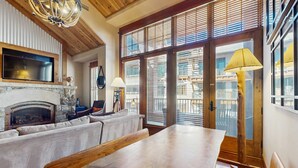Una sala de estar con chimenea, sofá y mesa de comedor.