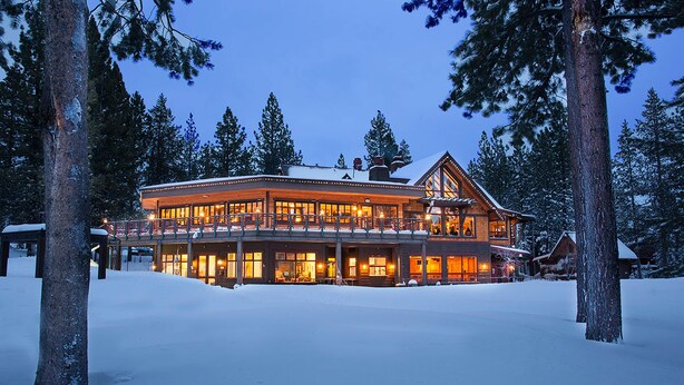 A large, multi-story lodge with a covered porch and multiple windows, surrounded by snow and trees. - Wooded Luxury at Modern Tahoe Donner Retreat with Private Deck in the Pines (Truckee)