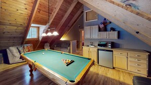 An attic room with a pool table, wooden cabinets, and a kitchenette. - Walkup Pines (South Lake Tahoe)