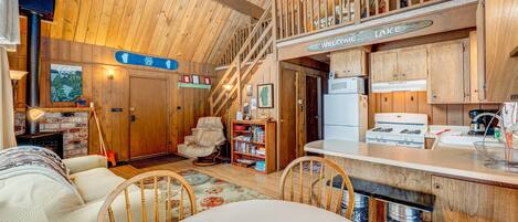 L’intérieur d’une cabane comprend une cuisine, un coin repas et un escalier menant à une mezzanine.