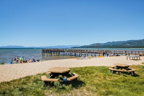 A beach with picnic tables, a pier, and a calm sea. - Three-Story Condo & Loft w Free WiFi, Gas Fireplace, Shared Pool, Hot Tub, & WD (South Lake Tahoe)