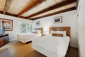 A bedroom with two beds, wooden beams on the ceiling, a dresser, and framed pictures on the walls. - Three-Story Condo & Loft w Free WiFi, Gas Fireplace, Shared Pool, Hot Tub, & WD (South Lake Tahoe)