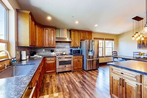 A modern kitchen with wooden cabinets, stainless steel appliances, and a large island. - Peaceful Mountain Getaway w/ 3 Decks & Hot Tub, Near Slopes, Hiking & Lake (South Lake Tahoe)