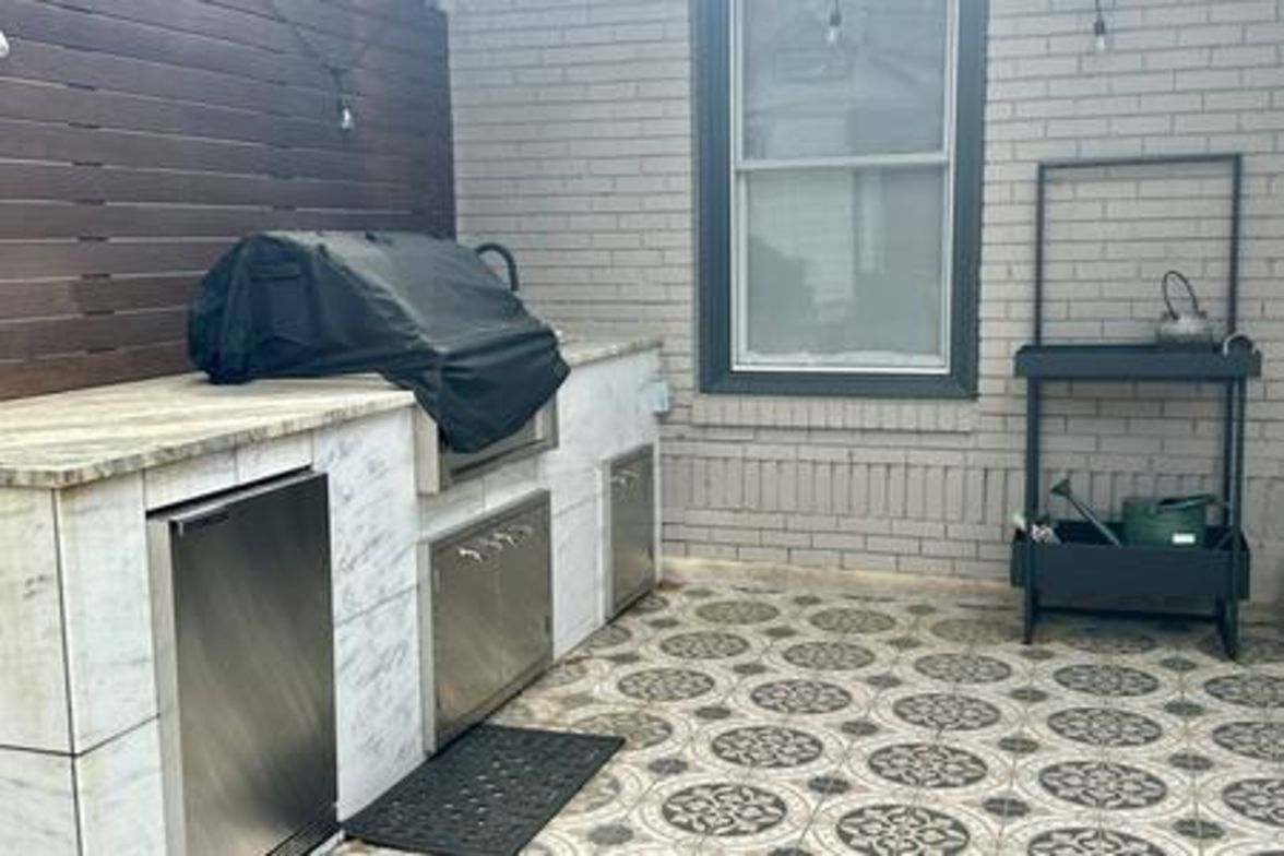 A kitchen with a tiled floor, a countertop, a sink, and a window.