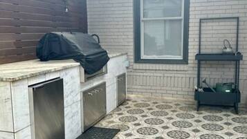 A kitchen with a tiled floor, a countertop, a sink, and a window.