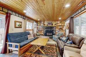 Ein gemütliches Wohnzimmer mit Kamin, Holzboden und Bücherregal.