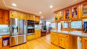 A kitchen with wooden cabinets, stainless steel appliances, and a granite countertop. - Mountain Home with Access to Shared Pool, Hot Tub, Sauna, & Tennis (Truckee)