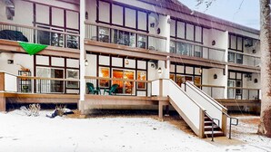 A multi-story building with a staircase, large windows, and outdoor seating. - Updated condo near ski resort with heated pool, hot tub, fireplace, balcony, W&D (Olympic Valley)