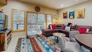 A living room with a sectional sofa, a round coffee table, and a patterned rug. - Updated condo near ski resort with heated pool, hot tub, fireplace, balcony, W&D (Olympic Valley)