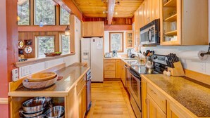 Una cocina con armarios de madera, un refrigerador, un microondas y una estufa.