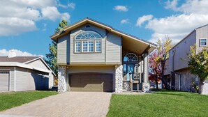 A two-story house with a garage, stone pillars, and a well-maintained lawn. - Charming Tahoe Keys Waterfront Retreat with Private Dock, Pool Table (South Lake Tahoe)