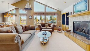 A spacious living room with a fireplace, large windows, and a dining area. - Charming Tahoe Keys Waterfront Retreat with Private Dock, Pool Table (South Lake Tahoe)