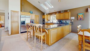 A spacious kitchen with wooden cabinets, a large island, and a skylight. - Charming Tahoe Keys Waterfront Retreat with Private Dock, Pool Table (South Lake Tahoe)
