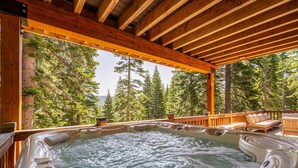 Boblebad med træterrasse og udsigt til høje træer.