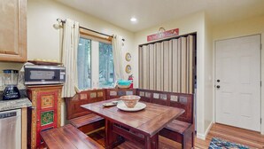 A kitchen with wooden furniture, a microwave, and a window with curtains. - Relaxing Dog-friendly home with gas grill & private fenced yard - close to marina (South Lake Tahoe)