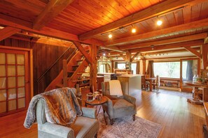 Un intérieur en bois comprenant un escalier, un coin repas et une cuisine.
