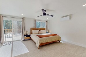 A bedroom with a bed, a ceiling fan, a nightstand, a lamp, and a view through a sliding door to an outdoor balcony. - Pristine Family Friendly Home with Large Decks, Near Hiking and Ski Resorts (South Lake Tahoe)