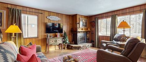 A cozy living room with a fireplace, leather sofa, and a television.