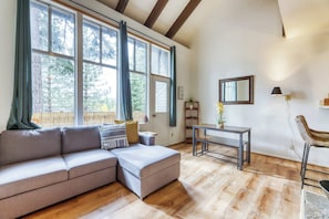 Un salon moderne avec un canapé d’angle, une petite table et un fauteuil.
