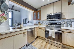 A modern kitchen with stainless steel appliances, wooden cabinets, and a tiled backsplash. - Cozy and Convenient Condo with Fireplace, Deck, W&D, Close to Town, Lake, Trails (Tahoe City)