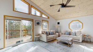 A spacious living room with a high ceiling, large windows, and a ceiling fan. - Pristine Family and Dog Friendly Mountain Home with Deck, BBQ, W&D (Truckee)