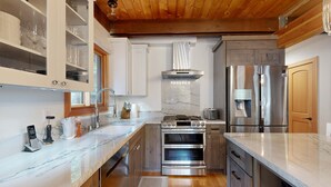 Una cocina moderna con armarios de madera, electrodomésticos de acero inoxidable y encimeras de mármol.