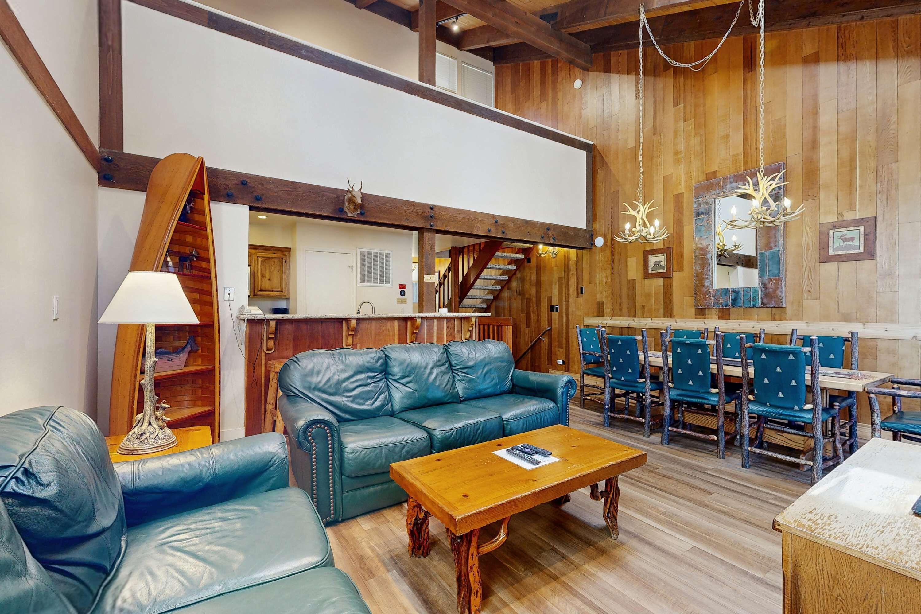 A spacious living area with a leather sofa, wooden coffee table, and a staircase leading to an upper level.