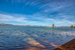 A calm lake with clear water, distant mountains, and a clear sky. - Dog-friendly home with pool table, fireplaces, & private hot tub, sleeps 10 (Zephyr Cove)