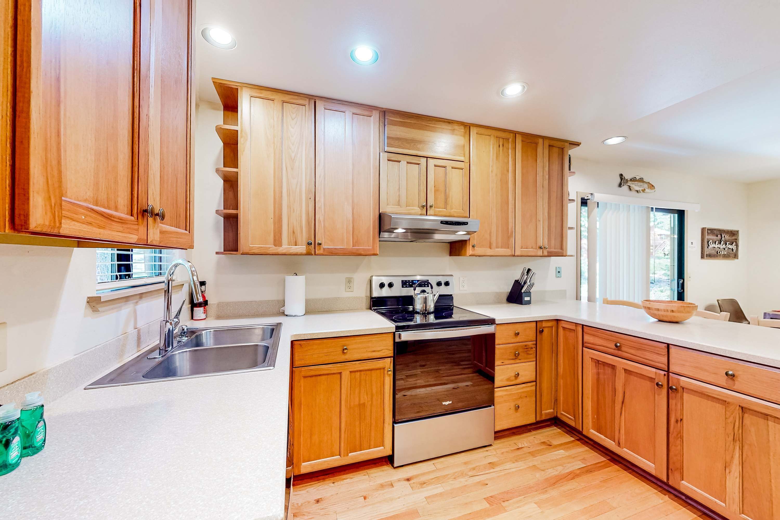Una cocina con armarios de madera, electrodomésticos de acero inoxidable y un ventanal.