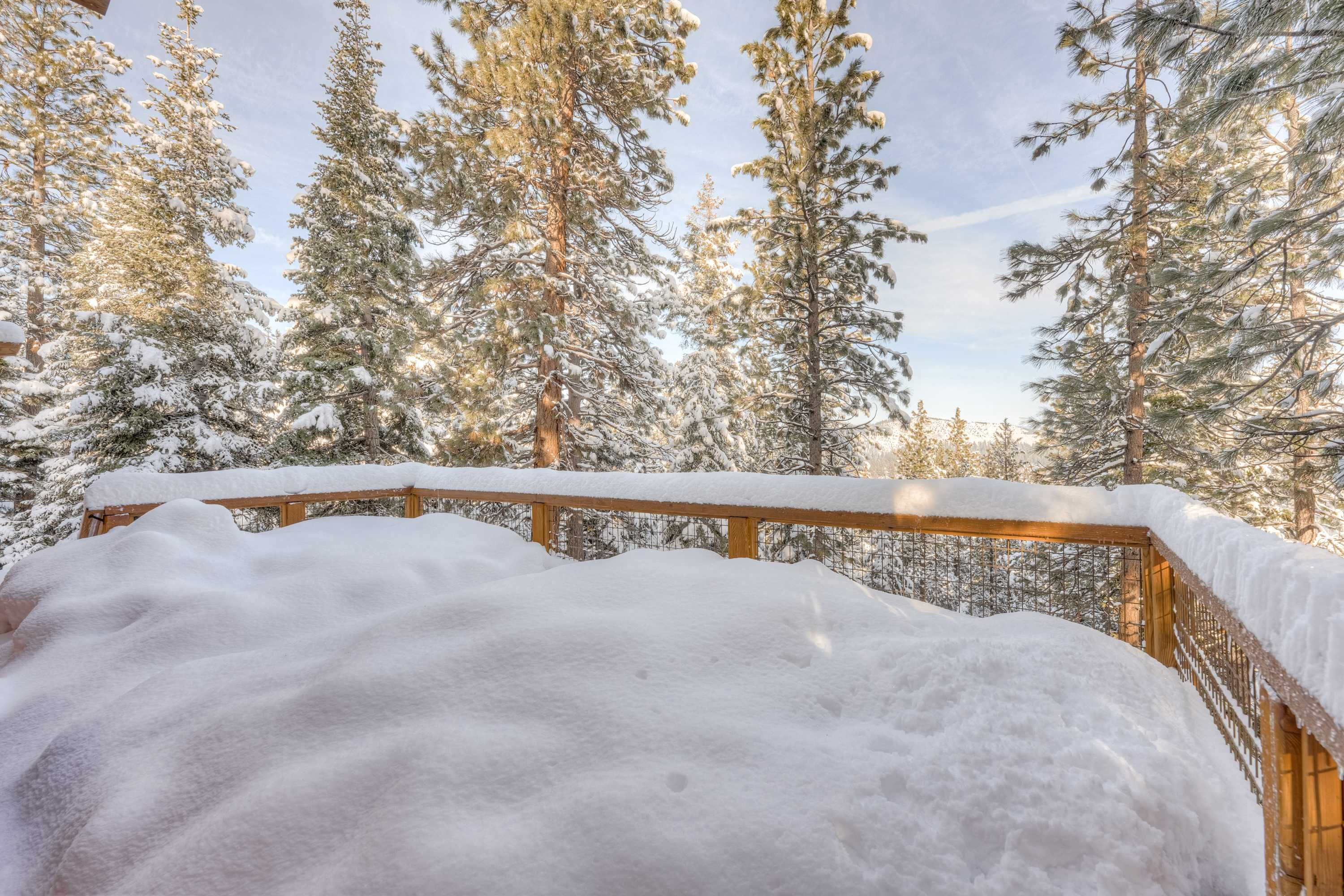 Une terrasse en bois recouverte de neige.