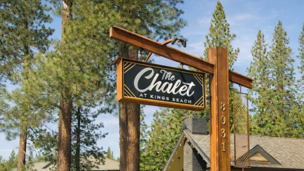 Ein hölzernes Schild mit der Aufschrift 'The Chalet at Kings Beach' und der Nummer '3031' an einem Pfosten.