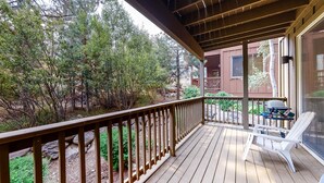 A wooden deck with a railing, a grill, and a chair. - Quiet mountain home w/private deck/gas grill/shared pool - near lakes (Truckee)