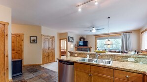 A kitchen with granite countertops, a dishwasher, wooden cabinets, a ceiling fan, and a television. - Quiet mountain home w/private deck/gas grill/shared pool - near lakes (Truckee)