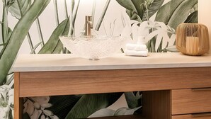 A bathroom vanity with a mirror, sink, and decorative plants.