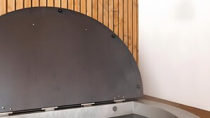 A modern kitchen with a built-in oven and a wooden ceiling.