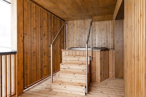 Een houten trap met metalen leuningen die uitkomt op een platform.